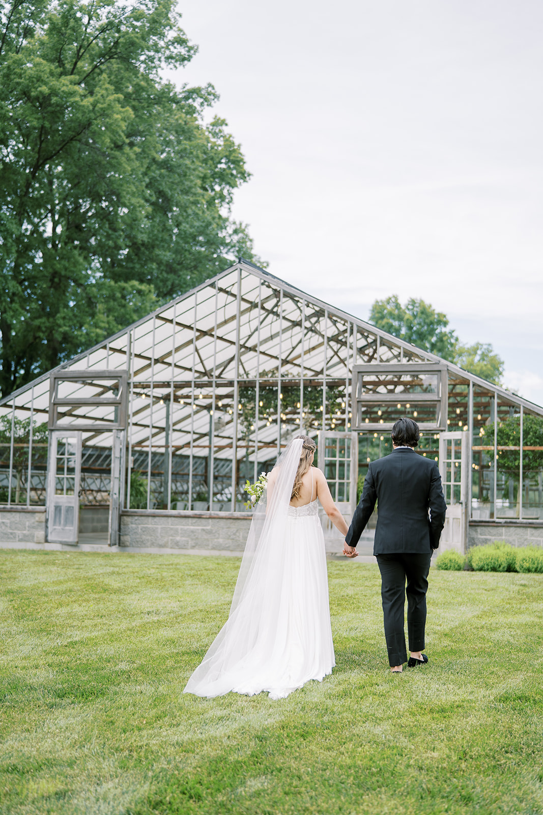 bride and groom by greenhouse at Jorgensen Farm Oak Grove
